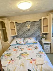 a bedroom with a bed with a floral bedspread at R&S Domek Gora in Darłowo