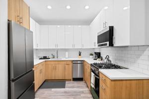 a kitchen with wooden cabinets and a black refrigerator at Prime 2BR Gem in River North Best Location!- Hubbard 2 in Chicago