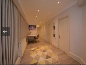 a hallway with a desk and a table in a building at 2 bedroom flat opposite Hyde Park & Royal Lancaster in London