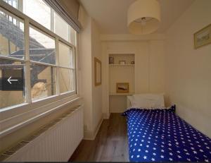 a bedroom with a bed and a large window at 2 bedroom flat opposite Hyde Park & Royal Lancaster in London