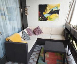 - un balcon avec un canapé, une table et un tableau dans l'établissement Waldeslust Villach Warmbad, à Villach