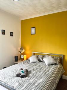 ein Schlafzimmer mit einem großen Bett mit gelber Wand in der Unterkunft THE PORT House in Birmingham