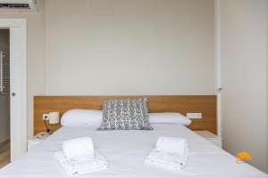 a bedroom with a white bed with two white towels at Malibu by Cadiz Time in Cádiz