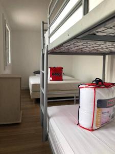 Zimmer mit 2 Etagenbetten und einer roten Tasche in der Unterkunft La Perle Marine in Le Vivier-sur-Mer