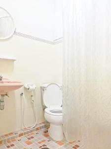 ein Bad mit einem WC und einem Duschvorhang in der Unterkunft YMCA International Hotel Chiangrai in Ban Fang Min