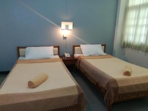 YMCA International Hotel Chiangrai في Ban Fang Min: سريرين في غرفة مع