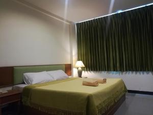 YMCA International Hotel Chiangrai في Ban Fang Min: غرفة نوم عليها سرير وفوط