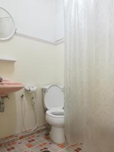 La salle de bains est pourvue de toilettes et d'un rideau de douche. dans l'établissement YMCA International Hotel Chiangrai, à Ban Fang Min