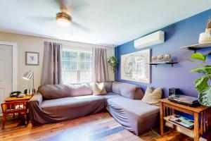 a living room with a brown leather couch and blue walls at Pleasant Beach Road Retreat in South Thomaston