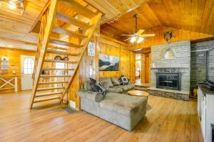 a living room with a couch and a fireplace at Riverfront Hadley Getaway with Fire Pit and Boat Dock! in Lake Luzerne