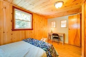 a bedroom with a bed and a desk and a window at Riverfront Hadley Getaway with Fire Pit and Boat Dock! in Lake Luzerne