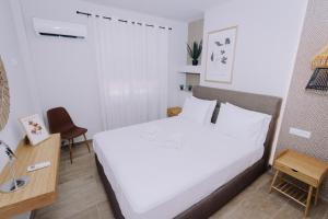 een slaapkamer met een groot wit bed en een bureau bij Vallia Suites-Green Luxury Suite A3 in Nafpaktos