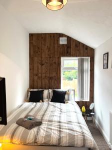 Schlafzimmer mit einem großen Bett mit einem Kopfteil aus Holz in der Unterkunft THE PORT House in Birmingham