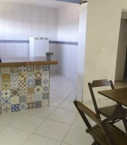 a kitchen with a counter and a table and a chair at Casa de Wagner in Triunfo