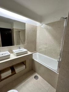 uma casa de banho com uma banheira, um lavatório e um chuveiro em Villa Valentina em Carvoeiro