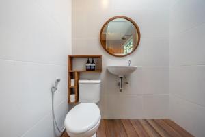a bathroom with a white toilet and a sink at ZenDen Wellness Guesthouse in Canggu