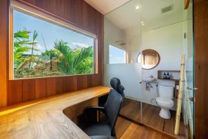 a bathroom with a window and a desk and a toilet at ZenDen in Canggu