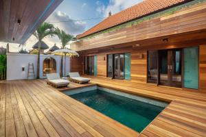 a house with a swimming pool and a wooden deck at ZenDen Wellness Guesthouse in Canggu +34 photos