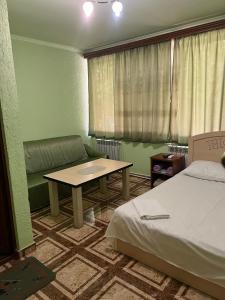 a room with a bed and a table and a couch at Touristic House KAEL in Musalerr