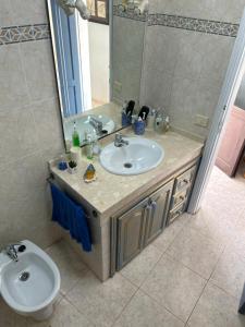 a bathroom with a sink and a toilet and a mirror at La Buganvilla rooms in Arrecife
