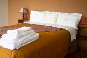 una pila de toallas sentadas encima de una cama en Los Alamos, en Caraz
