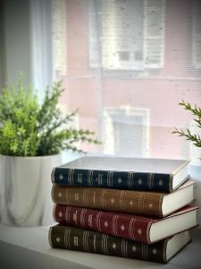 a stack of books on a table with a potted plant at 【】Le Prestigieux【】 , Belfort ville in Belfort +21 photos