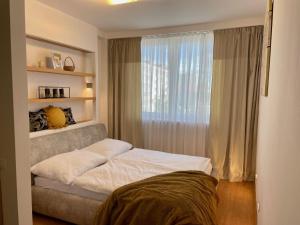 a bedroom with a bed and a large window at Resident Apartment in Košice