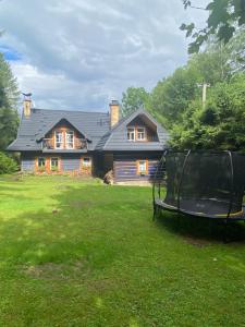 ein Haus mit einem Trampolin vor einem Hof in der Unterkunft Chalupa Tomas Jezersko in Jezersko