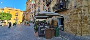 an outdoor cafe with an umbrella on a city street at Arte in piazza Agrigento centro in Agrigento