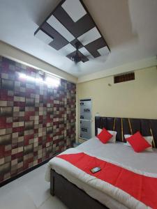 a bedroom with a bed with red pillows on it at Parvati home stay in Ujjain