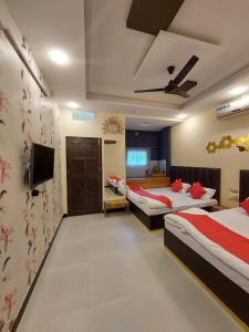 a hotel room with two beds and a tv at Parvati home stay in Ujjain