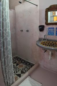 uma casa de banho com lavatório e piso em azulejo em Riad Lola em Sayulita