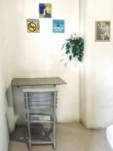 a table and a chair in a corner with signs on the wall at Riad Lola in Sayulita
