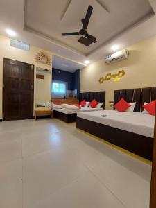 a bedroom with two beds and a ceiling fan at Parvati home stay in Ujjain