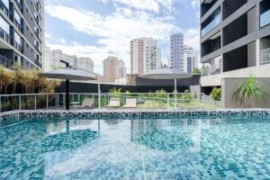 uma grande piscina com guarda-sóis num edifício em Tabas - VN Quatá em São Paulo