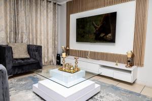 sala de estar con TV y silla negra en Fullmoon Two Bed Apartment, en Antwerp
