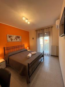 1 dormitorio con 1 cama con pared de color naranja en ENJOY MARTA en Marta