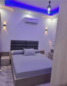 a bedroom with a bed with purple lights on it at SELENA BAY RESORT HURGHADa in Hurghada