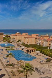 un complexe avec une grande piscine à côté de l'océan dans l'établissement SELENA BAY RESORT HURGHADa, à Hurghada