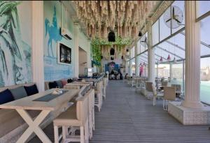 SELENA BAY RESORT HURGHADa في الغردقة: مطعم بطاولات وكراسي خشبية ونوافذ
