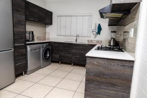 uma cozinha com armários de madeira e uma máquina de lavar e secar roupa em Fullmoon Two Bed Apartment em Antwerp