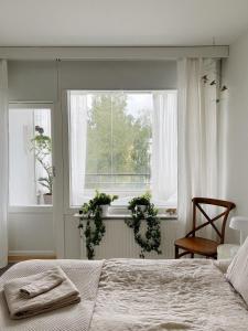 a bedroom with a bed and a window with towels on it at Cozy apartment with free parking in Espoo