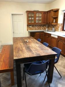 a kitchen with a wooden table and blue chairs at Gernant in Llanrug