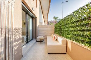 a patio with a couch and a green wall at Duplex Design, Terrasse résidence Menara garden in Marrakesh
