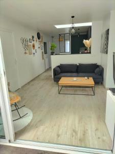 a living room with a couch and a table at Maison 100m² proche sites JO2024 in Élancourt