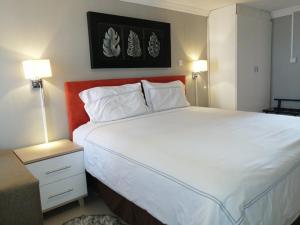 1 dormitorio con 1 cama blanca grande y 2 lámparas en Ranks Guesthouse, en Molepolole