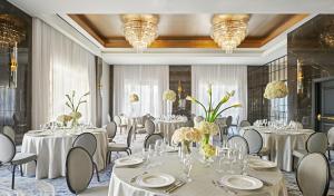 a banquet room with white tables and chairs and chandeliers at The LaSalle Chicago, Autograph Collection in Chicago