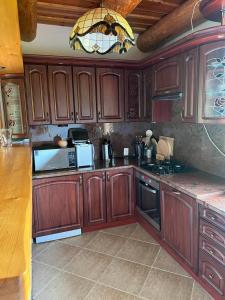 a kitchen with wooden cabinets and a chandelier at Zielkowa Ostoja in Niesiołowice