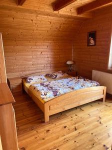 a bedroom with a bed in a wooden room at Zielkowa Ostoja in Niesiołowice