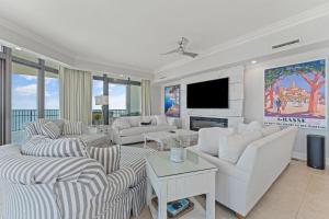 a living room with white furniture and a flat screen tv at The Oasis at Orange Beach 2411 (Phoenix West II) in Orange Beach